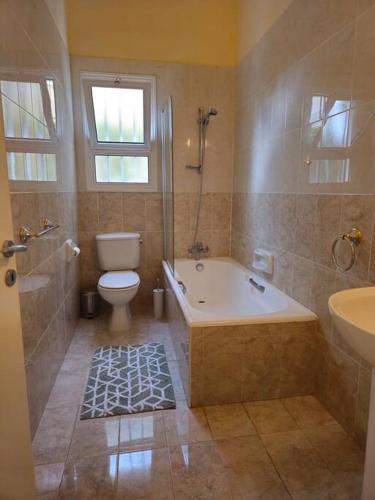 a bathroom with a tub and a toilet and a sink at Villa & pool 3 bedrooms 2 minutes from the beach in Maa