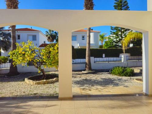 a white house with a white fence and a tree at Villa & pool 3 bedrooms 2 minutes from the beach in Maa