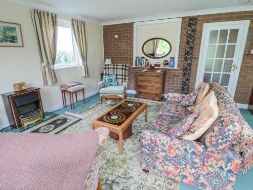 a living room with a couch and a table at Crosby Cottage in Wooler