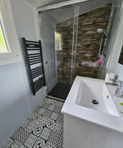 une salle de bain blanche avec un lavabo et une douche dans l'établissement Entre centre et plages, à La Tremblade
