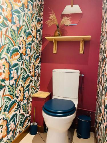 La salle de bains est pourvue de toilettes avec un siège bleu. dans l'établissement JolyHome, prestations de qualité entre Terre et Mer, à Maupertus-sur-Mer