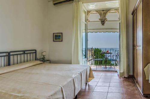 a bedroom with a bed and a view of the ocean at Hotel Bel Soggiorno in Taormina
