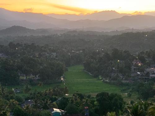 a view of a valley with a sunset in the background at Galkaduwa360 Villa in Kandy