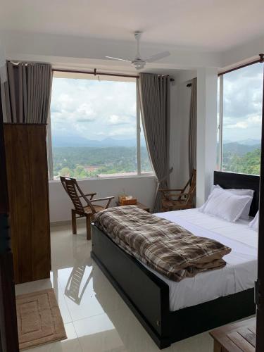 a bedroom with a bed and a large window at Galkaduwa360 Villa in Kandy