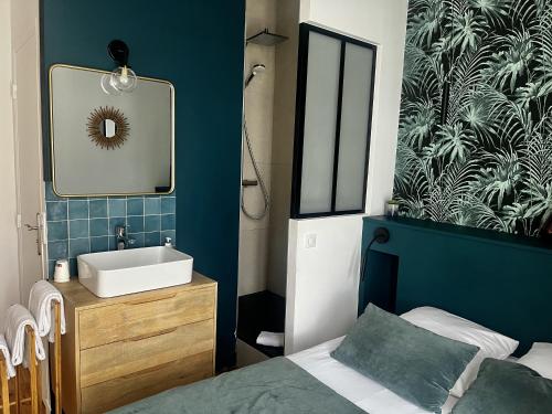 une salle de bain avec un lit, un lavabo et un miroir dans l'établissement Hotel de La Paix, à La Rochelle