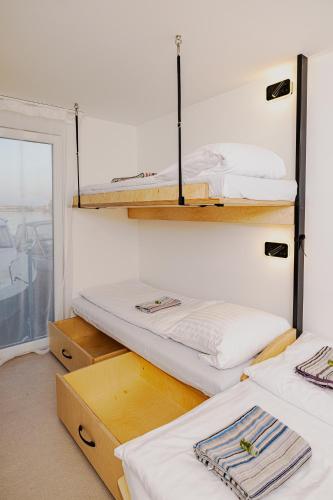 a room with three bunk beds and a window at YACHTER CLUB Modrá Čajka in Dunacsún