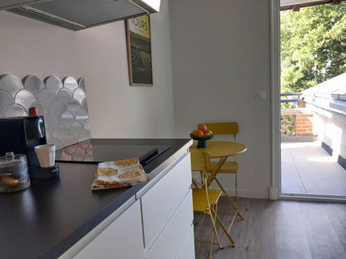 a kitchen with a black counter top and a table at Bel appart rénové avec terrasse in Saint-Avertin