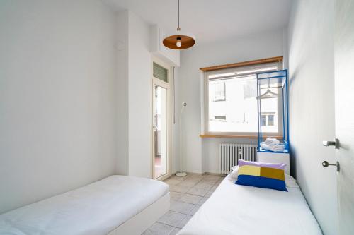 a small room with two beds and a window at Aosta Holiday Apartments - Promis in Aosta