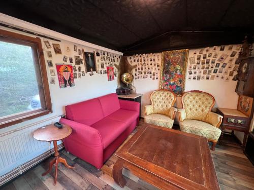 a living room with a red couch and chairs at Black house in the forest with Hot Tube and Home theater for movies in Līči