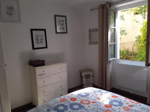une chambre avec un lit, une commode et une fenêtre dans l'établissement Joli F2 tout confort avec jardin, à Vichy