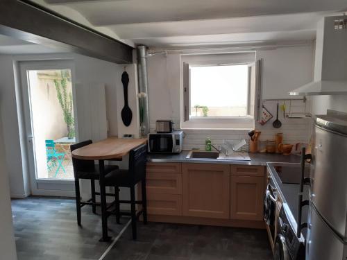 une cuisine avec un comptoir et une table à l'intérieur dans l'établissement Joli F2 tout confort avec jardin, à Vichy
