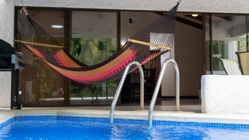 a hammock sitting next to a swimming pool at MonteMar Beach Condo At Playa hermosa in Sardinal