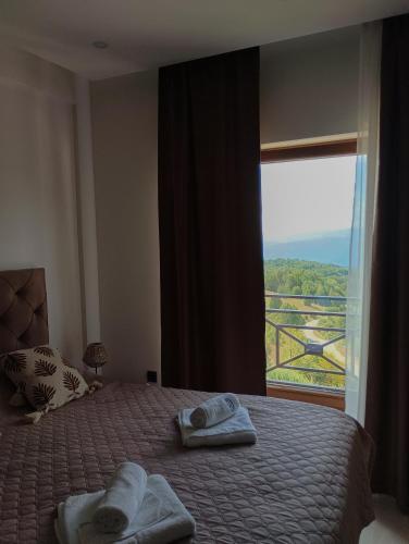 a bedroom with a bed with towels and a window at Milmari resort N12 in Kopaonik
