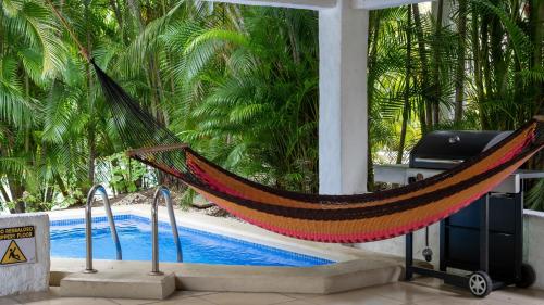 a hammock sitting next to a swimming pool at MonteMar Beach Condo At Playa hermosa in Sardinal