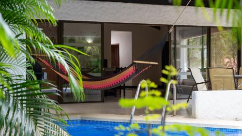 a hammock in a house with a swimming pool at MonteMar Beach Condo At Playa hermosa in Sardinal