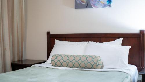 a bed with a wooden headboard and a pillow on it at MonteMar Beach Condo At Playa hermosa in Sardinal