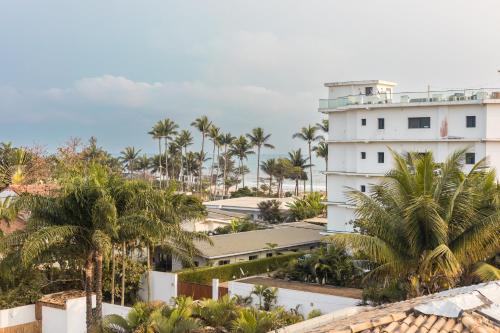 Blick auf ein weißes Gebäude mit Palmen in der Unterkunft Charmant appartement 2ch près de la plage in Pointe-Noire
