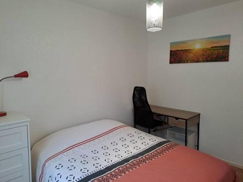 a bedroom with a bed and a desk with a lamp at Maison au calme 3 chambres avec terrasse et jardin in Ouzouer-sur-Loire
