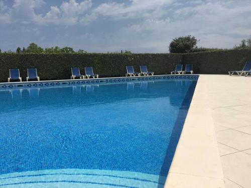 - une piscine avec des chaises bleues dans l'établissement L ECUME- Grand T4 duplex avec terrasses - Piscine - Parking, à Saint-Cyprien
