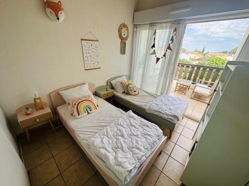 une petite chambre avec un lit et un balcon dans l'établissement L ECUME- Grand T4 duplex avec terrasses - Piscine - Parking, à Saint-Cyprien