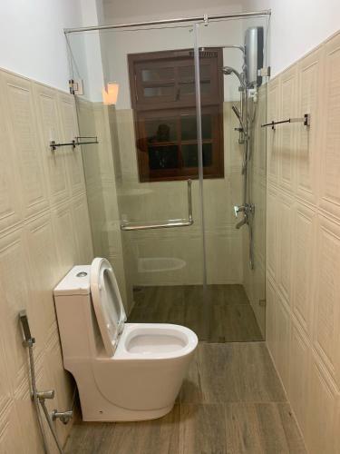 a bathroom with a toilet and a glass shower at Galkaduwa360 Villa in Kandy