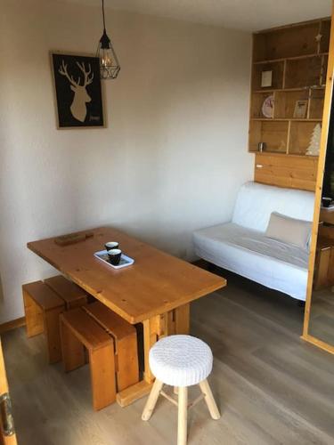Cette petite chambre comprend une table en bois et un lit. dans l'établissement La Plagne Bellecôte, à Plagne Bellecôte