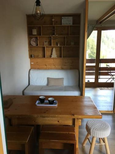 un salon avec une table en bois et un canapé dans l'établissement La Plagne Bellecôte, à Plagne Bellecôte