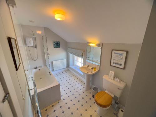 a bathroom with a tub and a sink and a toilet at Kirk House Longtown in Longtown