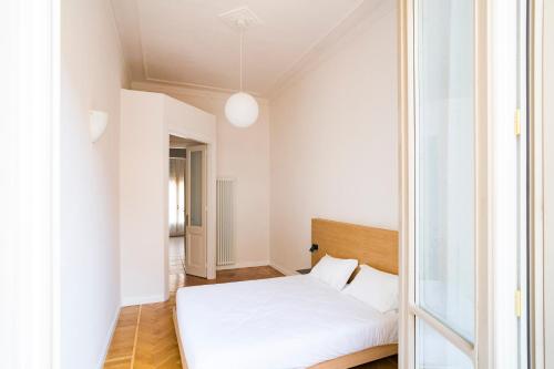 a small bedroom with a white bed and a window at Aosta Holiday Apartments - Conseil des Commis in Aosta