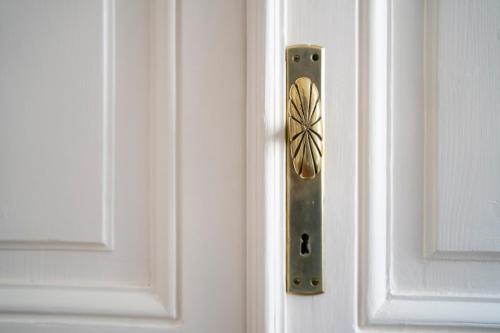 a metal door handle on a white door at Aosta Holiday Apartments - Conseil des Commis in Aosta
