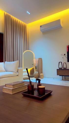 a living room with a couch and a table with books at Dirat Al-Ghizal 1 راس الخيمة قرية اذن in Gragrah