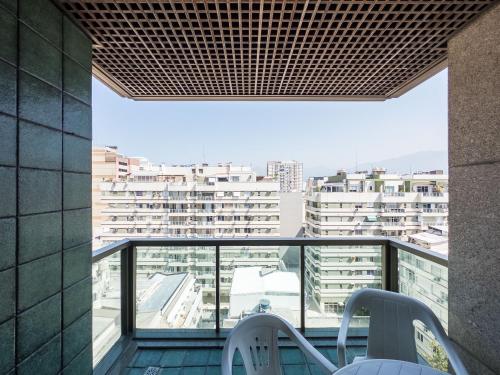 een balkon met 2 stoelen en uitzicht op de gebouwen bij IPF2045C - Tiffany's Residence Service - Ipanema in Rio de Janeiro