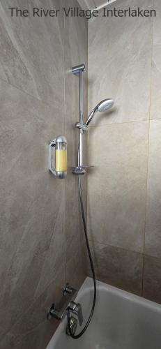 a shower in a bathroom with a bath tub at The River Village in Interlaken