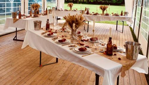 un groupe de tables avec des assiettes et des bouteilles de vin dans l'établissement Le Clos des Collières, à Marcollin