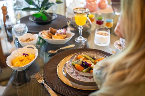 una mujer sentada en una mesa con un plato de comida en Estancia Don Pedro, en San Antonio de Areco