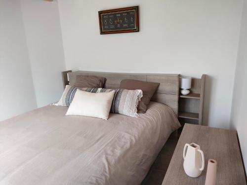 - une chambre avec un grand lit, des oreillers et une table dans l'établissement Calme sur l'ile d'Yeu, à L'Ile d'Yeu