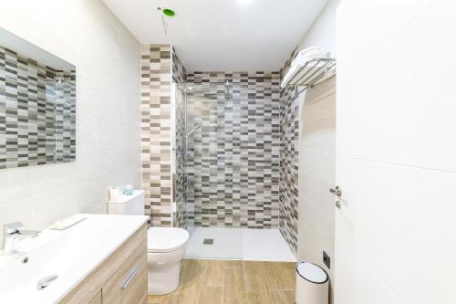 a bathroom with a toilet sink and a shower at Hotel Rural SOL in Piedrahita de Castro
