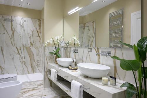 a bathroom with two sinks and a large mirror at Tornabuoni Suites Collection Residenza D'Epoca in Florence