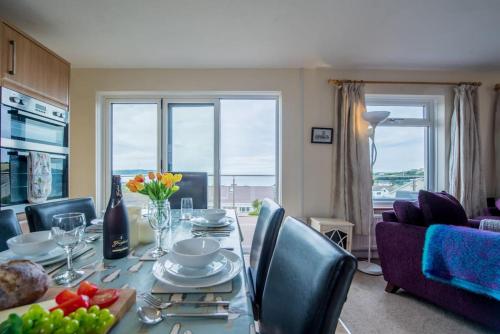 a dining room with a table and chairs with a view at PuffinPatch - Beachside Cottage in Broad Haven