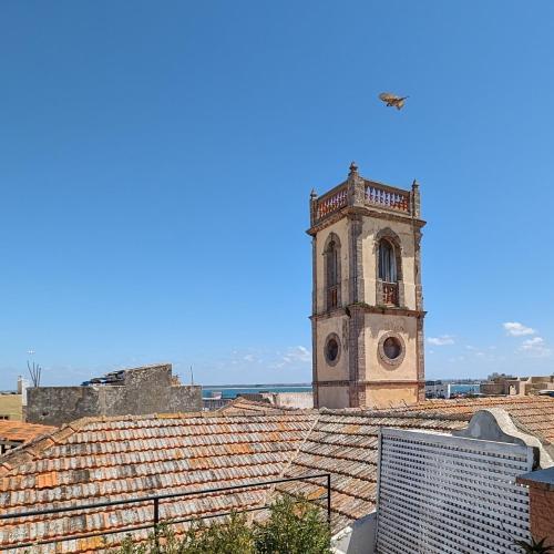 a building with a clock tower on top of a roof at Dar Ettaki Workation Riad Cité Portugaise Mazagan in El Jadida