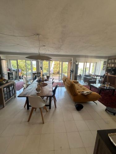 ein Wohnzimmer mit Sofa, Tisch und Stühlen in der Unterkunft Rez de chaussée villa avec piscine in Piana