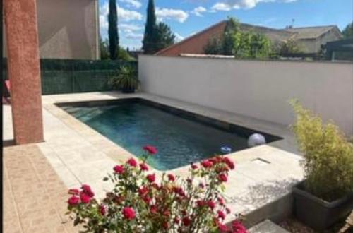 una piscina con fiori in un cortile di Maison 3 chambres de Sandrine et Julien a Saint-Privat-des-Vieux