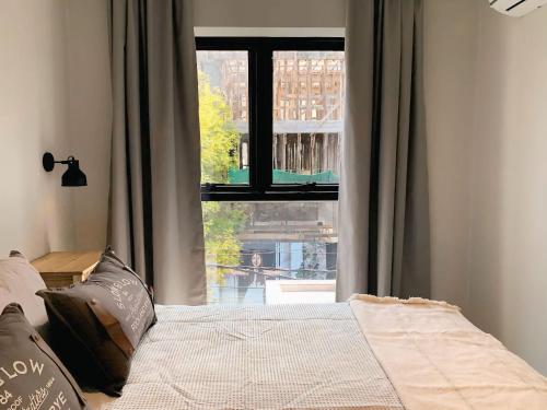 Un dormitorio con una cama y una ventana grande. en Smart AirLoft - Salta, en Salta