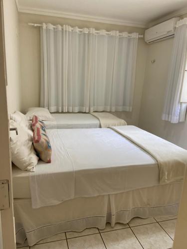 un letto con un animale di peluche seduto sopra di esso di Casa Sol-ampla com piscina no coração de Gostoso a São Miguel do Gostoso