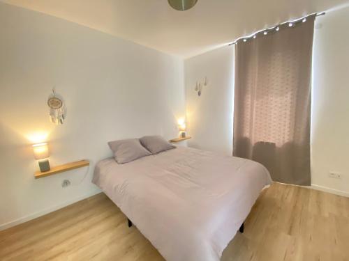 - une chambre blanche dotée d'un lit avec deux lumières dans l'établissement Maison double 4 chambres Duplex, à Brive-la-Gaillarde