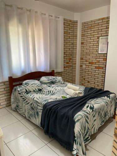 a bedroom with a bed with a zebra print sheets at Pousada Ramo de Acácia in Bombinhas