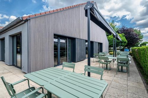a group of picnic tables and chairs in front of a building at Campanile Metz Sud Jouy-Aux-Arches A31 Carrefour de l'Europe in Jouy-aux-Arches