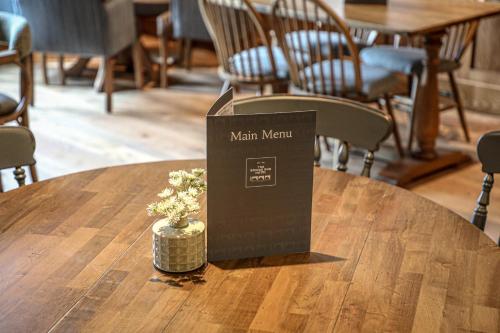 a sign on a wooden table with a vase on it at Bridge End Hotel in Llangollen