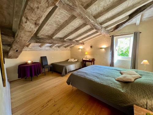 une chambre avec deux lits et une table et une fenêtre dans l'établissement Gîte la Maison du Queyran, à Villefranche-du-Queyran