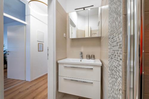 een badkamer met een wastafel en een spiegel bij Apartment Dora family only in Vodice